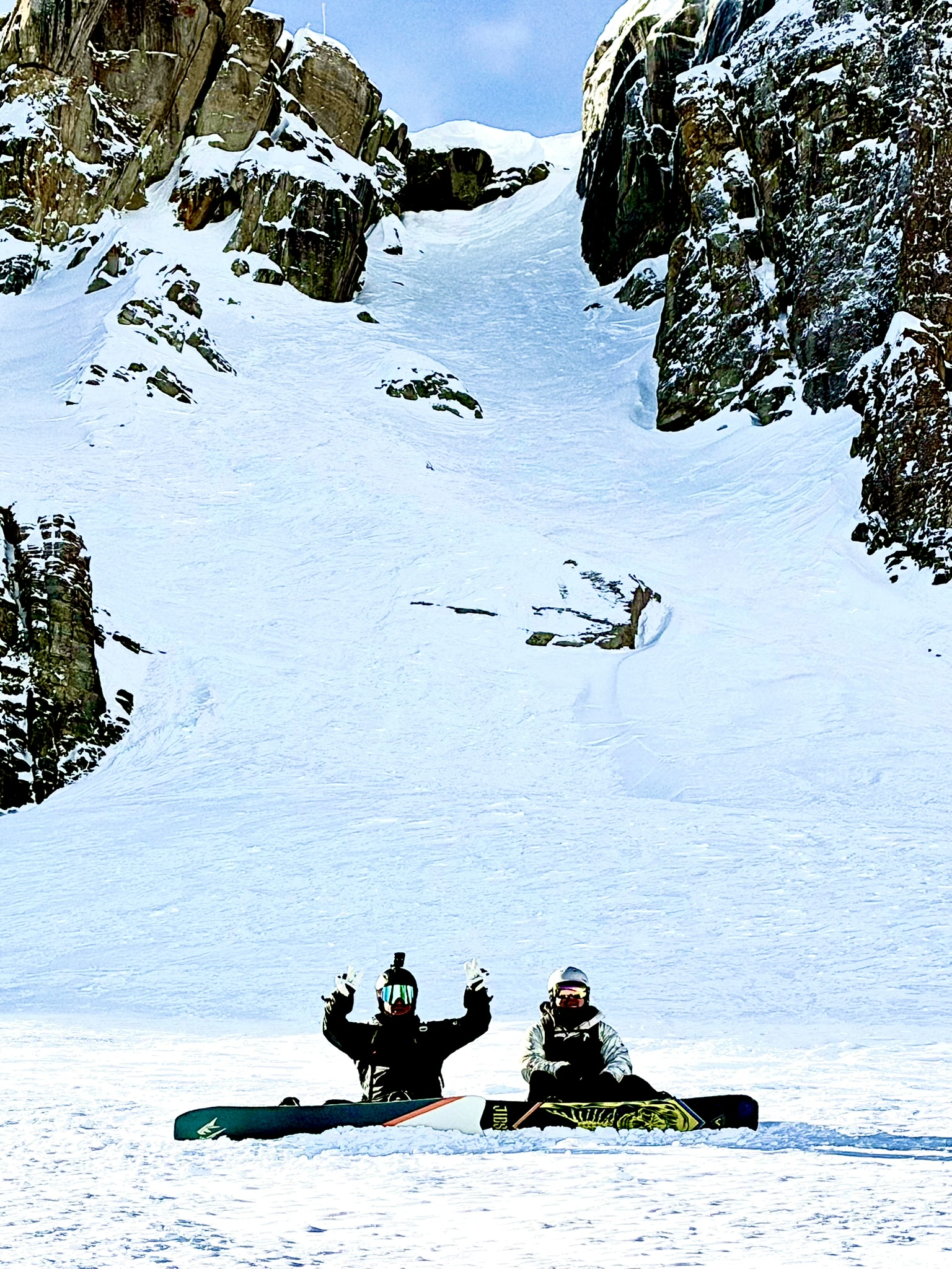 Brandon Reed and Ray White with snowboards beneath Corbet’s Couloir